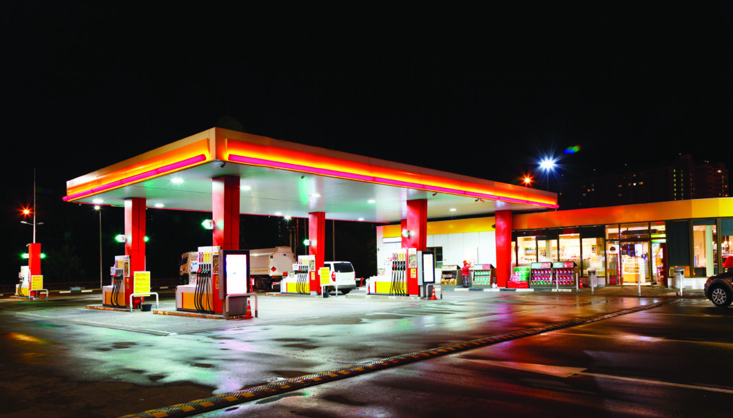 Petrol gas station station at night with lights on and mini-mart